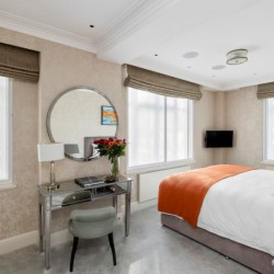 bedroom with dresser, mirror, king bed and TV, Hyde Park Apartments, Mayfair, London W1