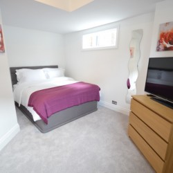 double bedroom with drawers and TV, Wardour Serviced Apartments, Soho, London