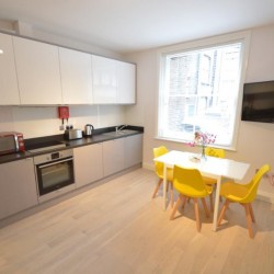 kitchen, dining table and TV, living area with double sofa bed and dining table, Anne’s Apartments, Soho, London W1