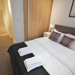 bedroom with king size bed, living area with double sofa bed and dining table, Anne’s Apartments, Soho, London W1