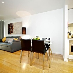 living area with wooden floors, sofa, dining table, kitchen,