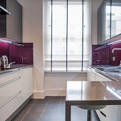 fully equipped kitchen with breakfast bar, living room with sofa, glass table, tv, chair and dining area, Garrick Charring Cross, Covent Garden, London WC2