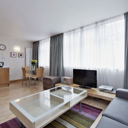 large living area with sofa, coffee table, tv, dining area and kitchen, Oxford Street Apartments, Marylebone, London W1