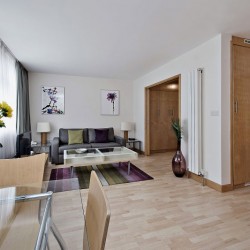 studio with wooden flooring, dining table with flowers, table and sofa, Oxford Street Apartments, Marylebone, London W1