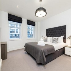 bedroom with double bed and towels, living room with sofa, glass table, tv, chair and dining area, Garrick Charring Cross, Covent Garden, London WC2
