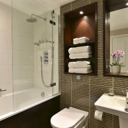 bathroom with shower over tub, towels, WC, sink and mirror, Queen's Apart Hotel, Kensington, London SW7