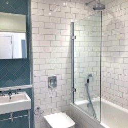 tiled bathroom with shower over bath tub