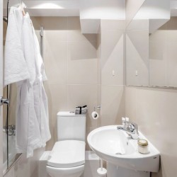 bathroom with toilet, bathrobes and sink Buckingham Apartments, Victoria, London SW1