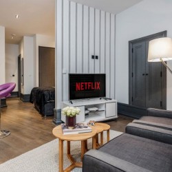 open plan living area with sofa, table, tv, dining table and view to sleeping area, Garrick Apartments, Covent Garden, London WC2