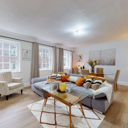 living room with wood flooring, glass table, sofa with pillows, chair and dining area, Clarges Apartments, Mayfair, London W1