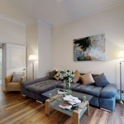living area with wood flooring, glass table, large sofa, lamps and wall art, Chesterfield Apartments, Mayfair, London W1