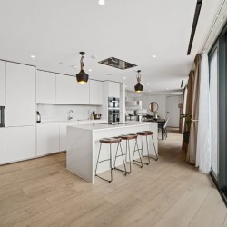 large white kitchen with breakfast bar, stools and view to dining area, 3 bedroom penthouse apartment