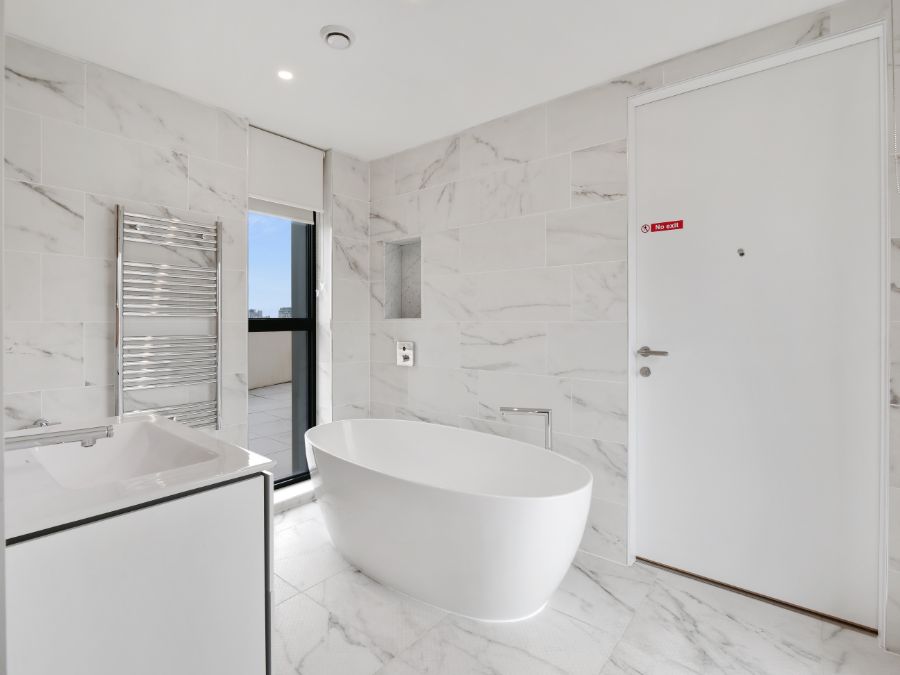 bathroom with free-standing bathtub, sink, towel rails, large door, 3 bedroom penthouse apartment