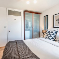 double bed with wardrobe and book shelves, Drury Lane Apartment, Covent Garden, London WC2