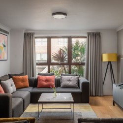 living room with corner sofa, table, wall art, lamp and TV, Kensington High Street, Kensington, London W8