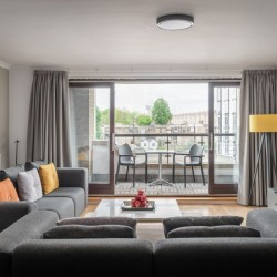 living room with 2 sofas, TV, table with fruit, balcony with seating, Kensington High Street, Kensington, London W8