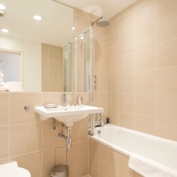 bathroom with shower over bathtub, sink and towels, Barrett Apartment, Marylebone, London W1
