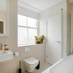 bathroom with rain shower over bath tub, toilet, sink and door, 1 bedroom apartment