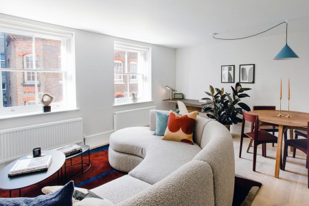 large round sofa with pillows, dining table and work desk, The Deluxe Apartments, Marylebone, London W1