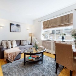living room with sofa bed, round table, dining area with flowers, Grosvenor Square Apartments, Mayfair, London W1