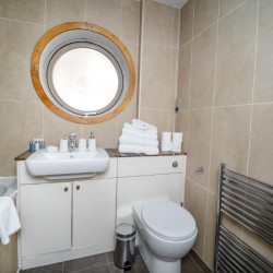 bathroom with round mirror, toiletries and towels, Piccadilly Circus, Soho, London SW1
