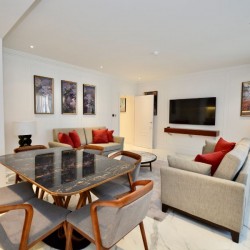 large living space with dining area, 2 sofas, works of art and tv, 2 bedroom super deluxe apartment
