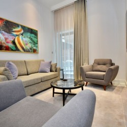 living area with sofa, large chairs, big works of art and wall mounted tv, St Johns Apartments, St Johns Wood, London NW8