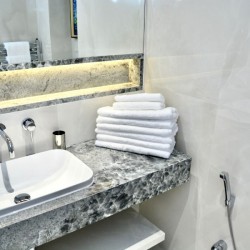 modern tiled bathroom with sink and stack of towels, St Johns Apartments, St Johns Wood, London NW8