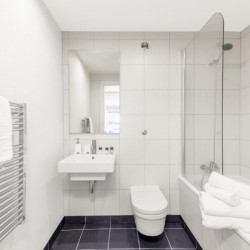 bathroom with towel rail, sink, mirror, toilet and bathtub, Sir John's Apartments, City, London EC4