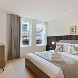 bedroom with chest of drawers and king size bed with towels, Mansion House Apartments, City, London EC4