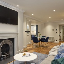 living room with fireplace, tv on wall, small table, sofa, and dining area, Mayfair Deluxe Apartments, Mayfair, London W1