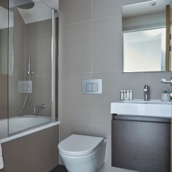 modern bathroom with bath tub, WC, and sink, The Mews Homes, Hammersmith, London W6