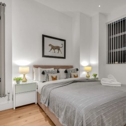bedroom with double bed, side tables with lamp and large window, Carlow Apartments, Camden, London NW1