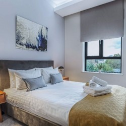 bedroom with side table, double bed, towels and print art on wall, Chancery Lane Apartments, Holborn, London W1C