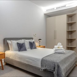 bedroom with double bed, towels, side tables and wardrobe, Chancery Lane Apartments, Holborn, London W1C