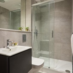 bathroom with sink, toiletries, mirror, toilet, shower and towel rack, Holborn Apartments, Holborn, London WC2