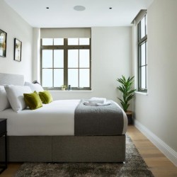 bedroom with double bed, window and large mirror, Holborn Apartments, Holborn, London WC2