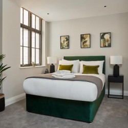 double bedroom with plant, bed with cushions and towels, side tables with lamps, Holborn Apartments, Holborn, London WC2