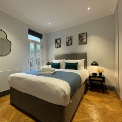 bedroom with side table, lamp and wardrobes, Barons Court Apartments, Hammersmith, London W6