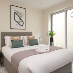 double bed, side table with lamp, double doors to patio, Munster Apartments, Fulham, London SW6