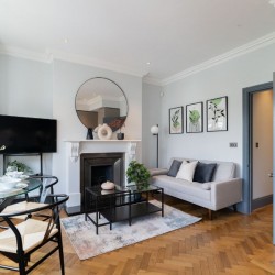 living are with dining table, large TV, fireplace, table and sofa, Barons Court Apartments, Hammersmith, London W6