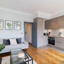 living room with sofa, small table and kitchen, Barons Court Apartments, Hammersmith, London W6