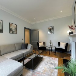 living area with l-shape sofa, table, 2 chairs, art and mirror on wall, Barons Court Apartments, Hammersmith, London W6