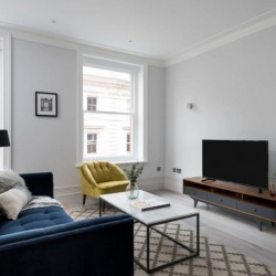 living area with sofa, chair, small table, and TV on stand, West End Apartments, Holborn, London W1C